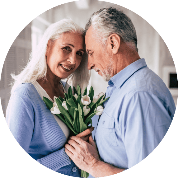 Elderly couple embracing each other with flowers