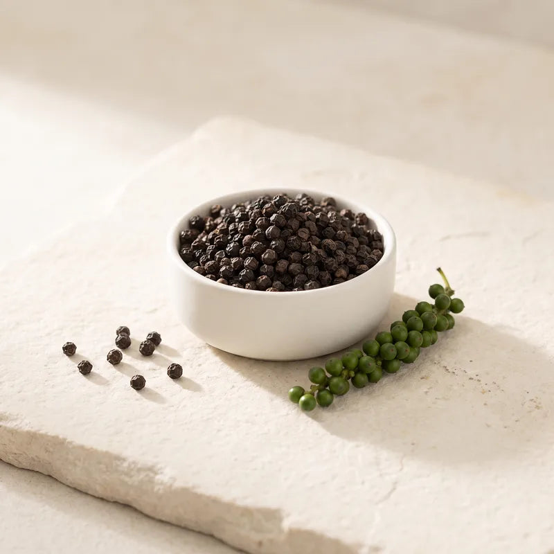 Dish of whole black peppercorns